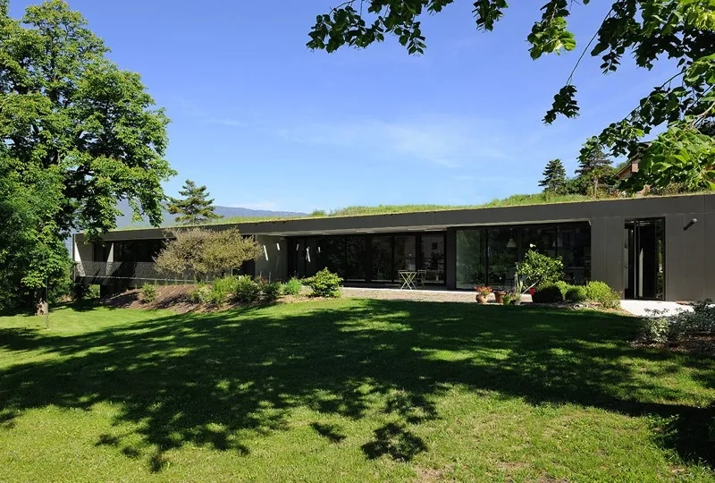 La maison tourne volontairement le dos aux constructions avoisinantes, côté nord, a n d’orienter tous les espaces vers le sud et les vues dégagées sur le paysage. La toiture- terrasse est entièrement végétalisée de façon intensive.