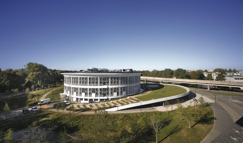 La toiture végétalisée de l’extension, directement accessible depuis le sol, devient une prolongation des espaces verts du campus.