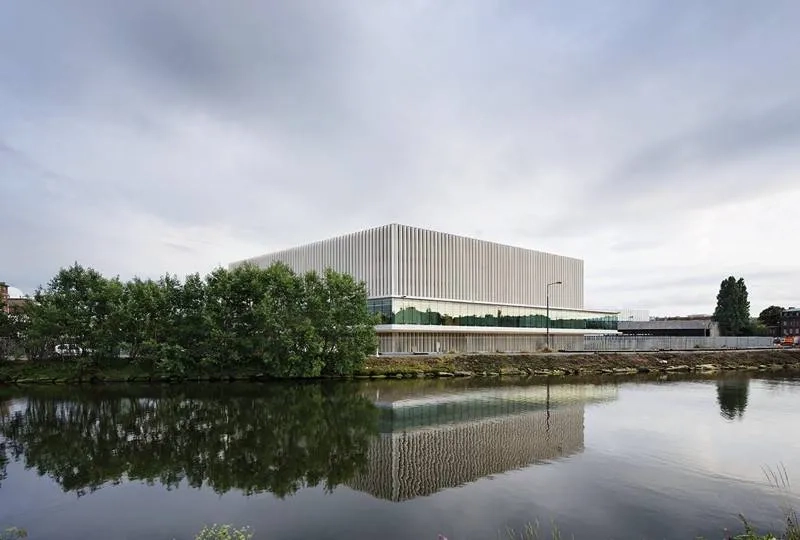 Façade nord sur le canal. Le choix de matériaux pérennes et le soin de leur mise en œuvre participent de l’image du palais. entre les fines colonnes de béton, la double peau vitrée assure un tampon thermique.