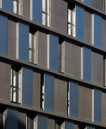 Jeu de lignes et joli contraste des matières avec ces volets en métal associés au béton lasuré de la façade.