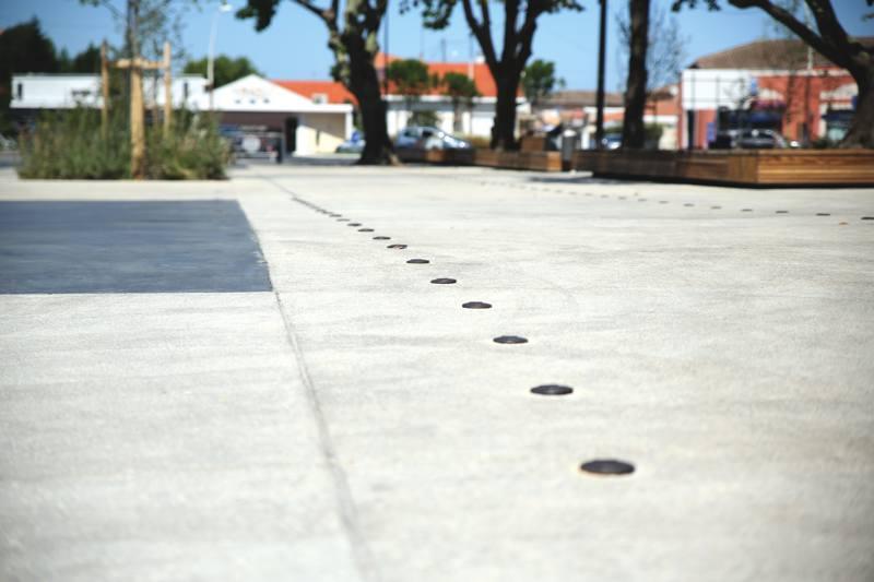 Des inserts pour le repérage du cheminement et l’e et de perspective. En médaillon, le béton noir lissé, réalisé côté est, pour créer un contraste.