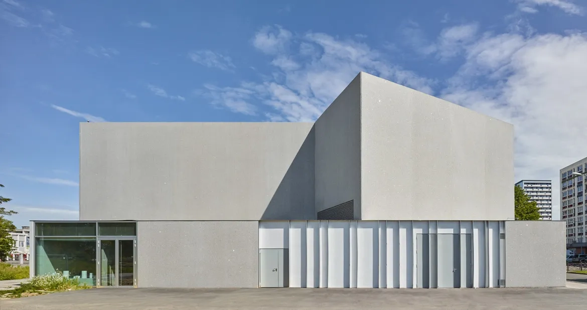L’enveloppe du bâtiment est rythmée par les grands plans vitrés et les parois verticales en béton gris poli ou bouchardé. des éclats de miroir sont incorporés au béton. ils scintillent sous le soleil et animent les façades de façon changeante et inattendue. L’enveloppe du bâtiment est rythmée par les grands plans vitrés et les parois verticales en béton gris poli ou bouchardé. des éclats de miroir sont incorporés au béton. ils scintillent sous le soleil et animent les façades de façon changeante et inattendue.