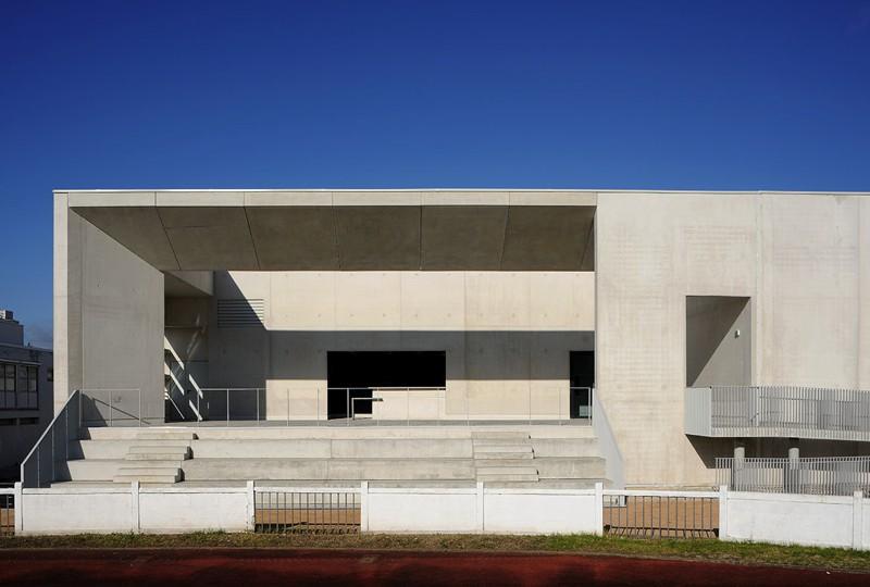 Sur la façade arrière, côté buvette, gradins et rampe font le lien avec le stade existant.