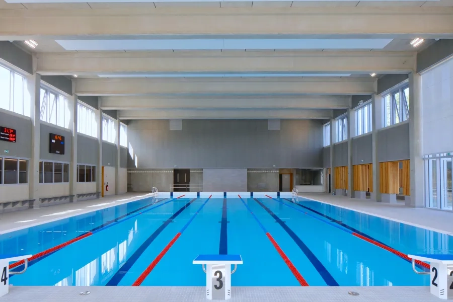 Profitant du décalage entre les toitures, dans la hauteur des murs latéraux, des impostes vitrées cadrent le ciel. DEPRICK_MANIAQUE_Roye_Eqpt_Centre aquatique_P-Ruault_Roye 11. La nouveau halle bassin_0.jpg