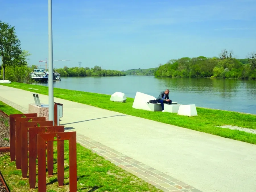 Le mobilier urbain (bancs, chaises, luminaires, porte-vélos) associe minéral, bois et métal.