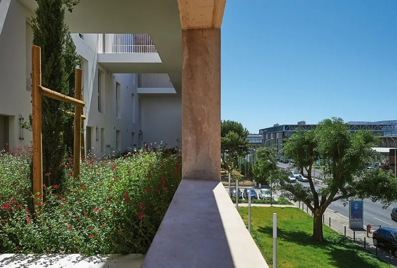 Le mur en béton teinté, le long du boulevard, crée un écran à la fois acoustique et visuel.