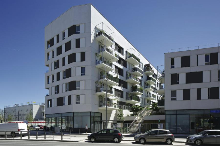 Depuis la rue, l’accès aux logements se fait par un vaste escalier central doublé d’un ascenseur. Les rez-de- chaussée sont ainsi libérés pour laisser un maximum de surfaces commerciales.