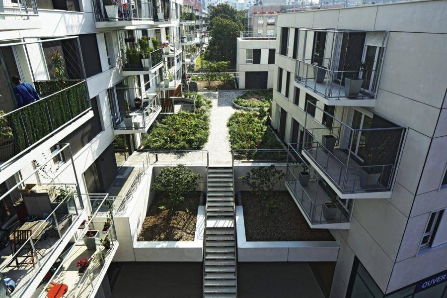 Depuis la rue, l’accès aux logements se fait par un vaste escalier central doublé d’un ascenseur. Les rez-de- chaussée sont ainsi libérés pour laisser un maximum de surfaces commerciales.