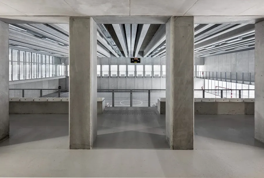 La monochromie du béton est apaisante et pérenne. Les tribunes surplombent la salle et ont une capacité de 160 places assises.