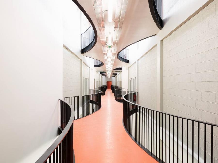 Dans la halle technique, à l’étage, une passerelle en béton slalome entre les salles.