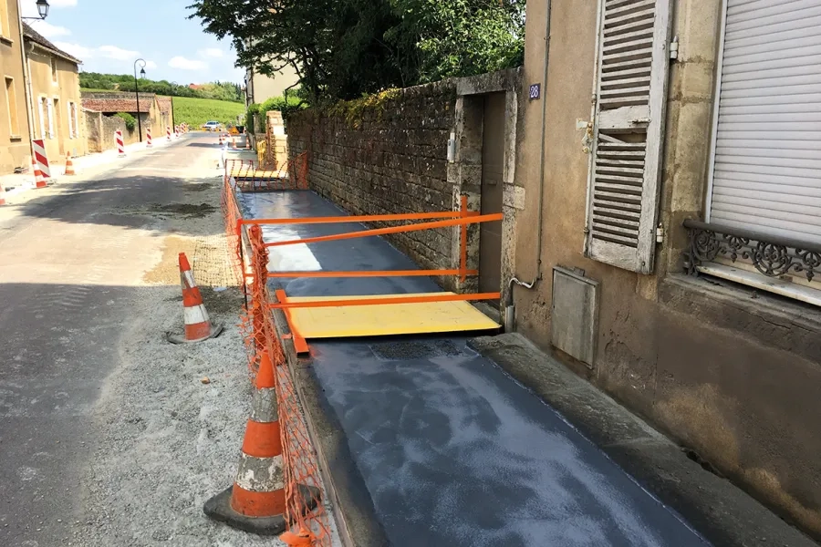 Rue de Beaune. Trottoirs en béton désactivé. À noter les passerelles pour assurer l'accessibilité et la protection du chantier.