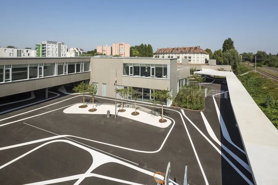 Les cours de récréation (ici, celle de l’école élémentaire) sont protégées des nuisances de voies ferrées par un mur écran. Les cours de récréation (ici, celle de l’école élémentaire) sont protégées des nuisances de voies ferrées par un mur écran.