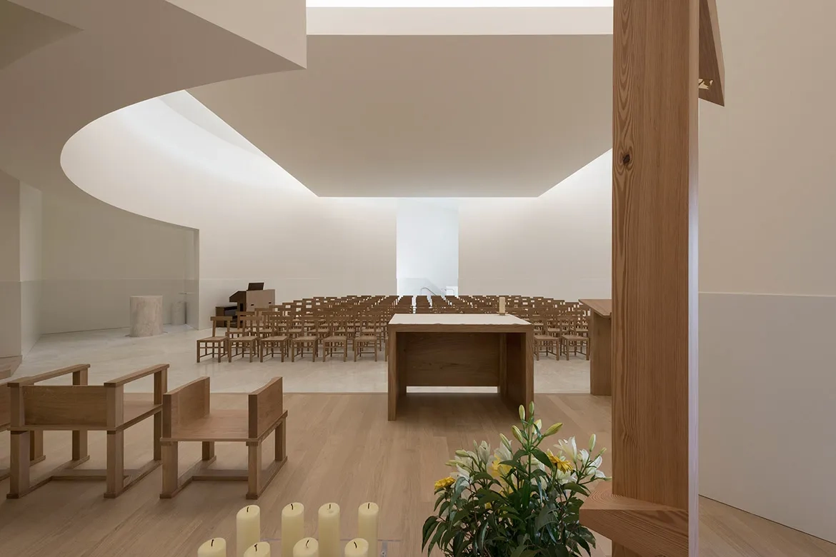 La courbe de l’église est marquée en hauteur par une poutre en béton suspendue qui assure le report des charges sur les descentes verticales. La courbe de l’église est marquée en hauteur par une poutre en béton suspendue qui assure le report des charges sur les descentes verticales.