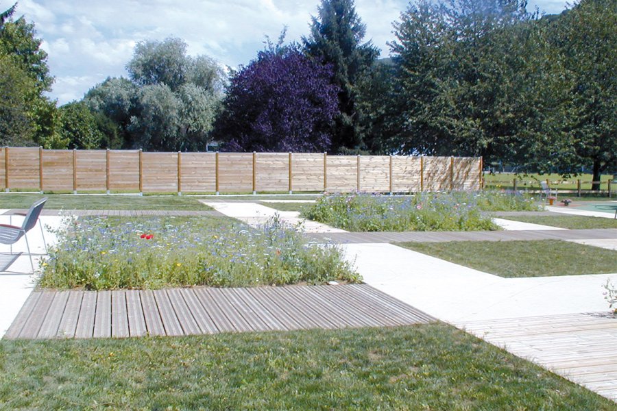 en bordure de route et du Doubs, le square de Velotte (2 800 m2) compte deux aires de jeux pour enfants. ses cheminements réalisés en béton décoratif Articimo® (holcim Bétons) micro- désactivé de ton pierre s’harmonisent parfaitement avec les autres matériaux utilisés : le bois (pour le platelage) et la pierre (pour le pavage).