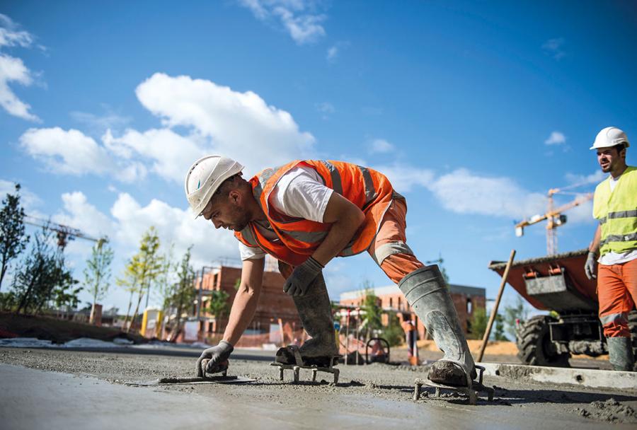 Après serrage, le béton frais a ensuite été finement taloché par des équipiers montés sur des chaussures à clous.