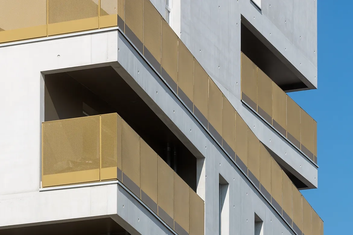 Peints en doré, les garde-corps des loggias répondent  aux façades  en béton clair.  