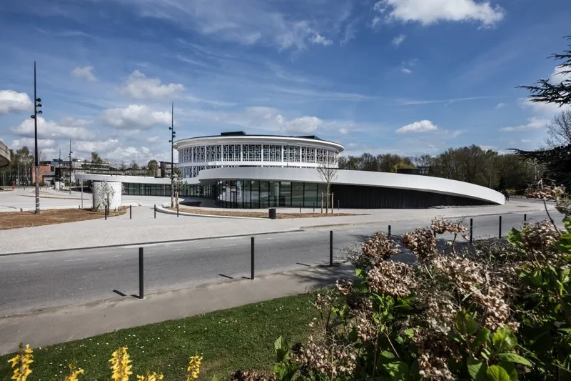 L’acrotère blanc en béton dessine un renfoncement qui libère au sol un vaste parvis.