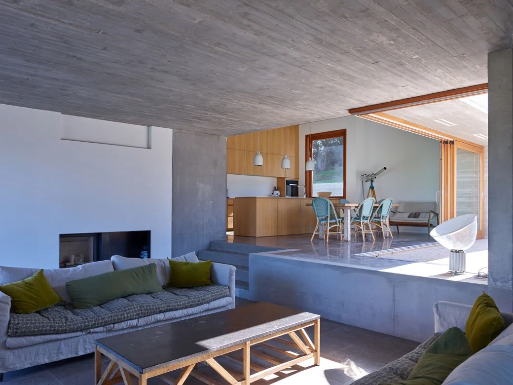 À l’intérieur, l’espace de vie est vaste et bénéficie d’un jeu de hauteur entre la salle à manger et le salon. Le béton est présent en sous-face de dalle pour créer un lien visuel entre l’intérieur et l’extérieur. À l’intérieur, l’espace de vie est vaste et bénéficie d’un jeu de hauteur entre la salle à manger et le salon. Le béton est présent en sous-face de dalle pour créer un lien visuel entre l’intérieur et l’extérieur.
