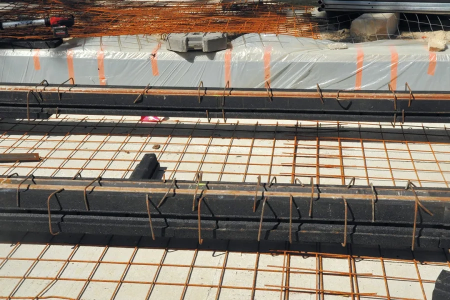 Deux rails en jaquette positionnés sur le béton de fondation, avec adjonction d’une nappe de treillis soudé, en attente du béton de calage.