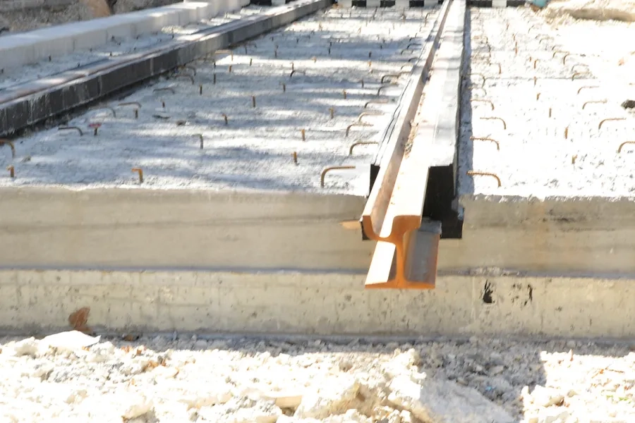 Un rail enrobé dans son complexe en caoutchouc (« jaquette »). Après coulage du béton de calage (vue des connecteurs en surface),  en attente du coulage du béton de revêtement. 