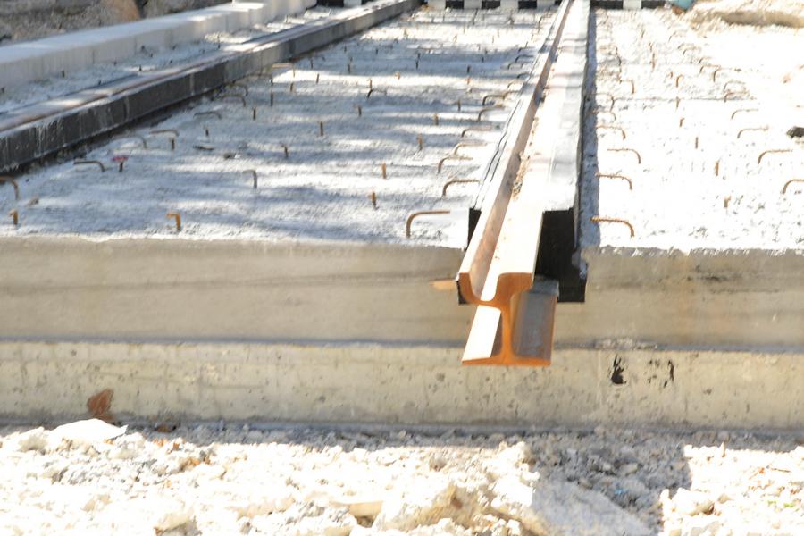 Un rail enrobé dans son complexe en caoutchouc (« jaquette »). Après coulage du béton de calage (vue des connecteurs en surface),  en attente du coulage du béton de revêtement. 