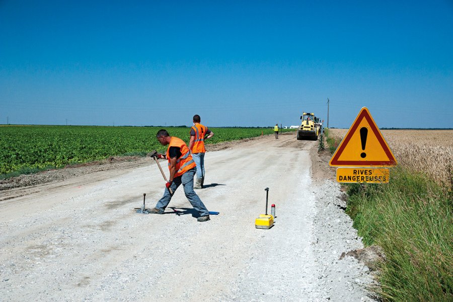 À droite, contrôle de la régularité de l’épandage et de la quantité des liants réalisé par la méthode dite « à la bâche ». À gauche, préparation d’un test de compacité. En médaillon, résultat à l’issue du malaxage : le liant clair a été finement mélangé  avec le matériau de l’ancienne chaussée. 