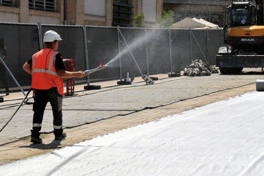 Un géotextile est déployé pour protéger la nouvelle chaussée. But : renforcer encore la prise du béton. Il sera arrosé toutes les heures jusqu'au soir.