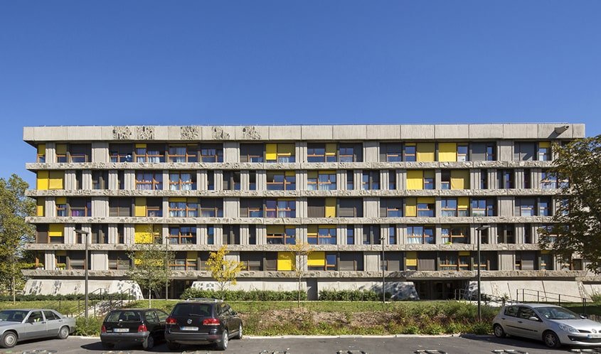 L’architecture met en œuvre trois matériaux selon les principes dits « brutalistes » : béton brut avec inclusion de blocs irréguliers de schiste, menuiserie bois, verre.