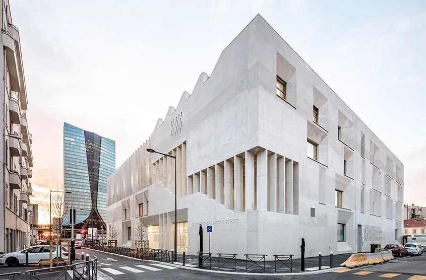 Sur l’avenue Salengro et la rue Urbain V, le bâtiment se perçoit comme un monolithe sculpté en béton clair.