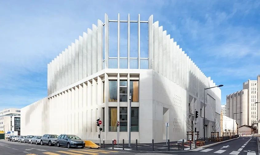 Sur la rue Antoine de Ruffi, la colonnade de poteaux hexagonaux en béton vient enclore les deux cours de récréation et offre une protection solaire performante pour les expositions est et ouest.