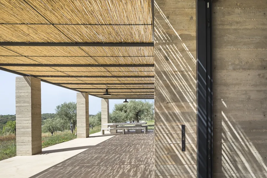 Protégée par une tonnelle légère reposant sur des piliers massifs, une profonde pergola étend les pièces de vie sur toute la longueur de la façade sud-est.