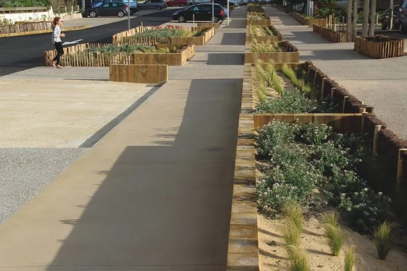 Les trottoirs en béton de sable, agrémentés de jardinières.