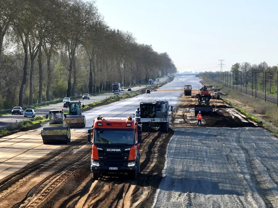 RN7. Vue générale du chantier de mise en œuvre de la couche de forme traitée au liant LV-TS 03. À gauche, l'actuelle RN7, bordée de platanes, et, à droite, la ligne SNCF Paris – Clermont-Ferrand. (©Roger Martin)