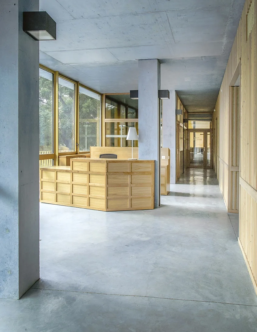 Hall d’entrée du CFA caractérisé par le béton bleu des poteaux, du sol et du plafond.